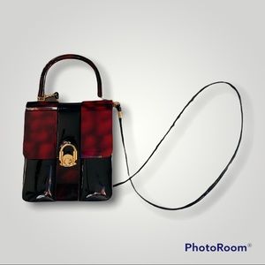 Vintage patent leather Crossbody/handle With red plastic accent and handle.